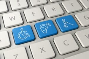 Keyboard with blue keys depicting a wheel chair symbol, an ear listening, and person with a mobility cane.
