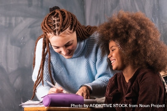Adult supporting a student at a desk