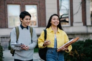 Two students walking with backpacks on